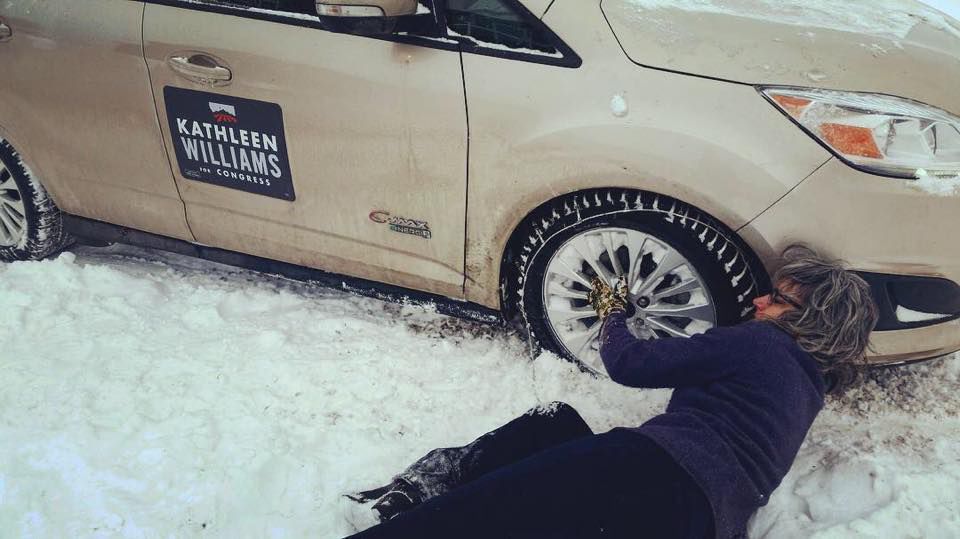 Williams putting on tire chains outside Baker